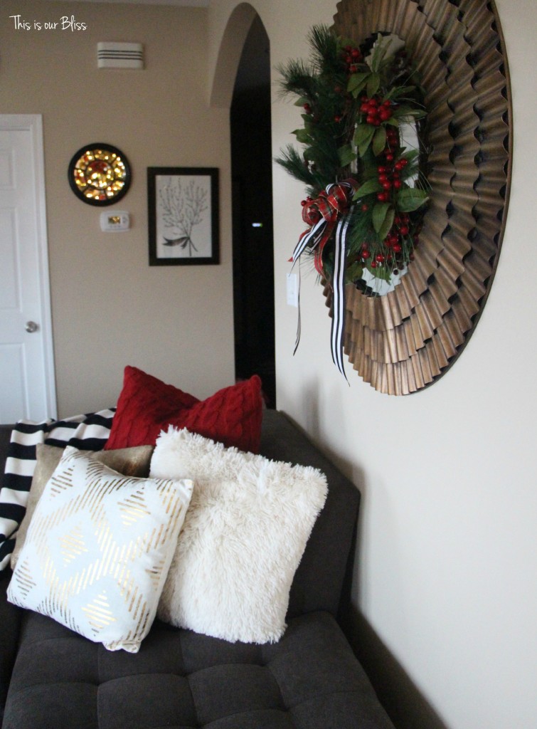 family room couch with holiday pillows - sunburst mirror with wreath - This is our bliss