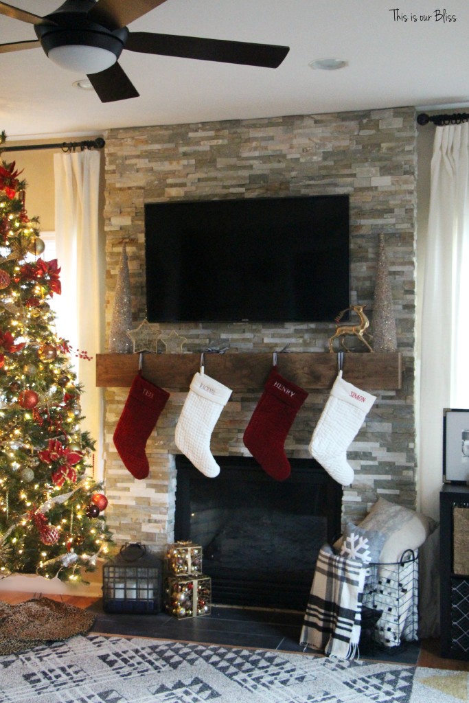 family room tree - stockings hung on mantle - stacked stone fireplace - floating mantle - This is our Bliss